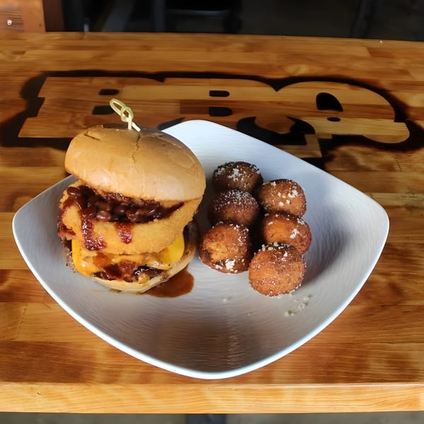 BBQ House Bar & Grill's BBQ burger with onion rings, baked beans, cheese, and hush puppies.